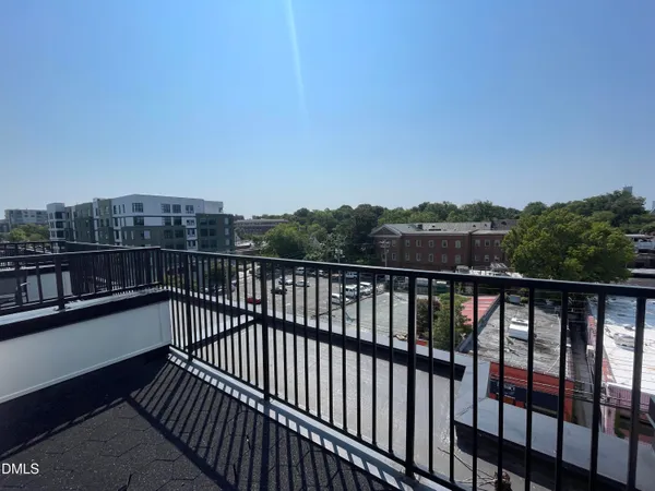 a balcony with wooden floor and city view