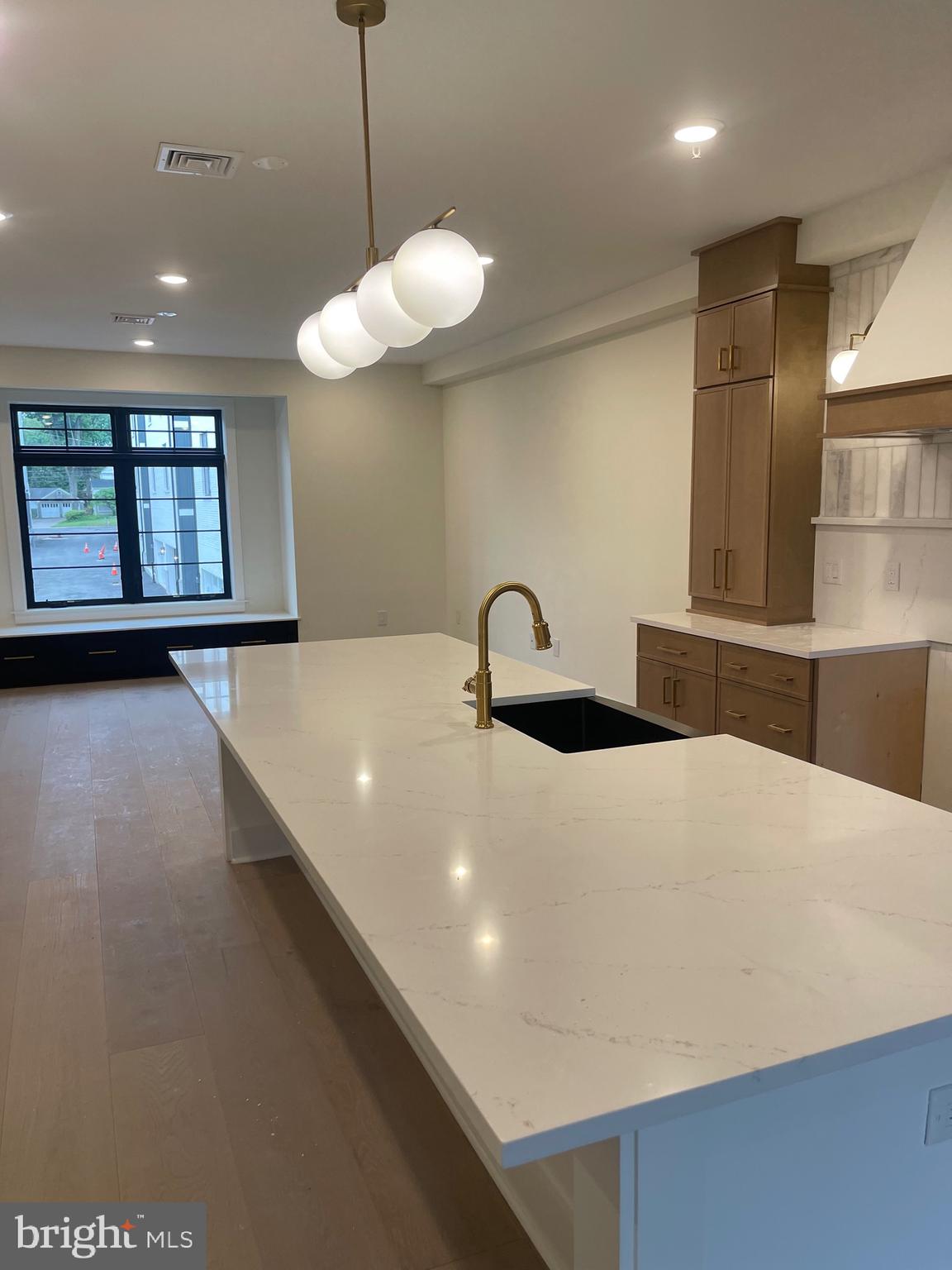 7519 Ridge Avenue Philadelphia, PA 19128 - Photo 4 of 26 a large kitchen with stainless steel appliances a large counter top a chandelier and a wooden floor