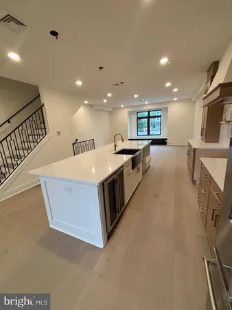 a large kitchen with stainless steel appliances a large counter top