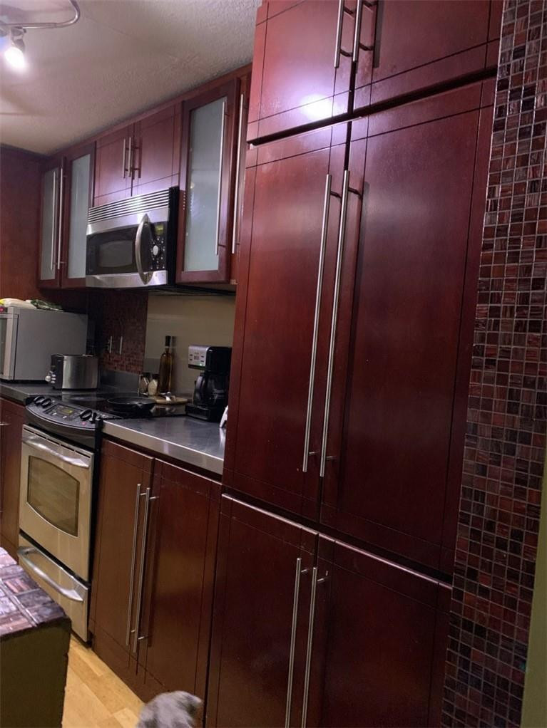 8244 9th Court, Unit 8 Plantation, FL 33324 - Photo 3 of 10 a kitchen with stainless steel appliances granite countertop a refrigerator and a stove top oven