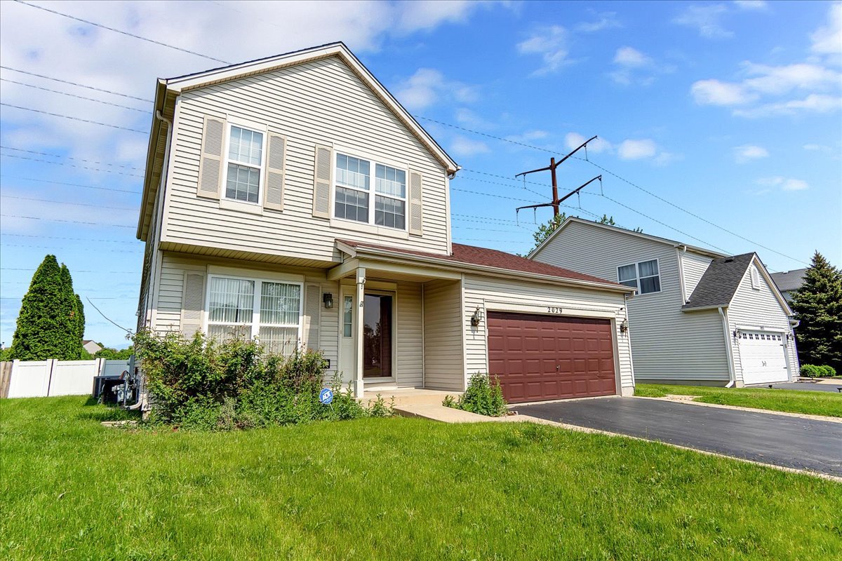 2029 Ridgemoor Drive Plainfield, IL 60586 - Photo 2 of 26 a front view of a house with a yard and garage