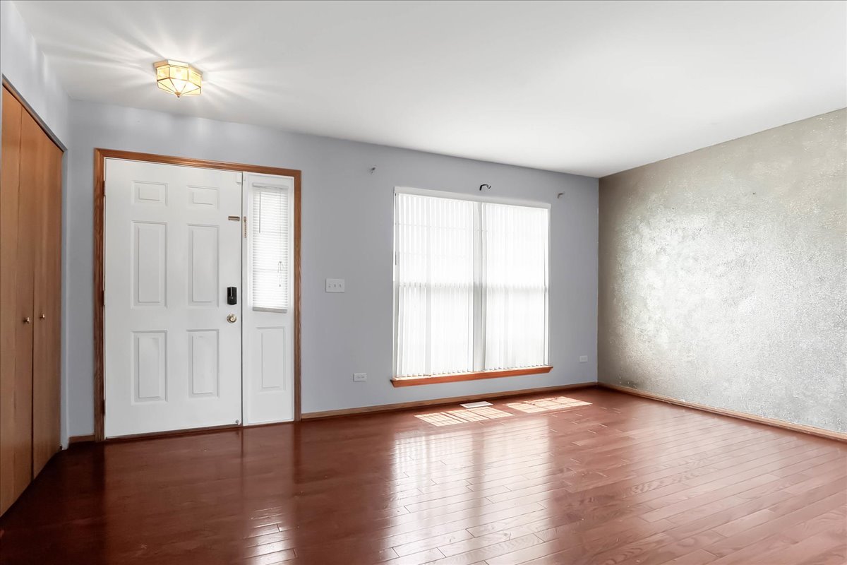 2029 Ridgemoor Drive Plainfield, IL 60586 - Photo 5 of 26 a view of an empty room with wooden floor and a window