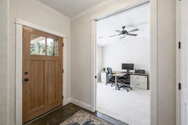 a view of a workspace with furniture and a window