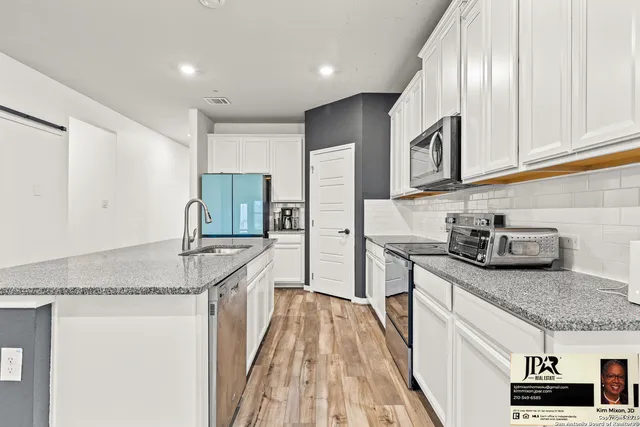 a kitchen with stainless steel appliances granite countertop a sink stove and cabinets