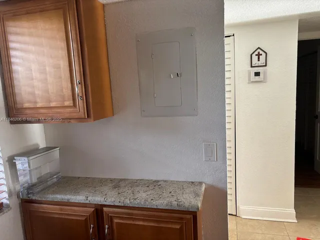 a kitchen with granite countertop a sink and a white cabinets