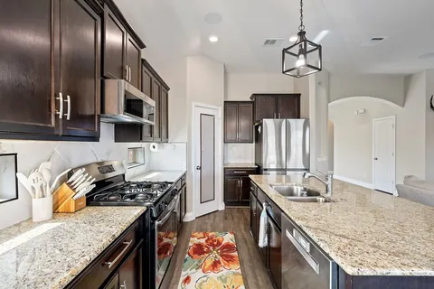 a kitchen with stainless steel appliances granite countertop a stove oven and a refrigerator
