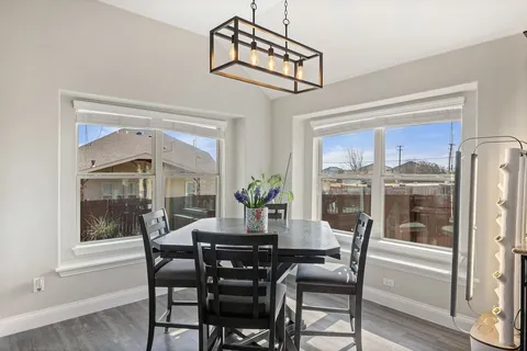 a dining room with furniture a chandelier and wooden floor