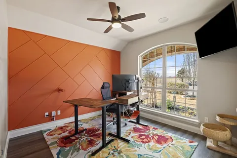 a work room with furniture and a floor to ceiling window