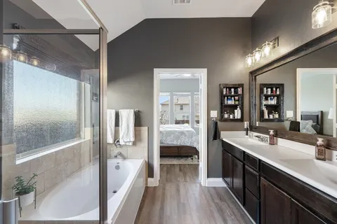 a en suite bathroom with a double vanity sink a large mirror and shower
