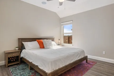 a bedroom with a bed and wooden floor