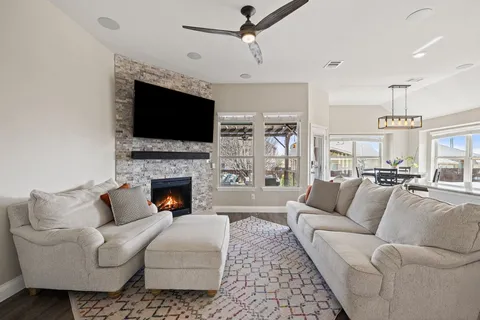 a living room with furniture a flat screen tv and a fireplace
