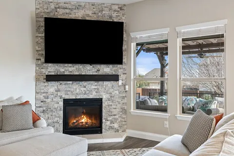 a living room with furniture a flat screen tv and a fireplace