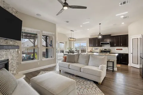 a living room with stainless steel appliances furniture and a flat screen tv