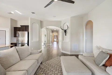 a living room with furniture and a chandelier
