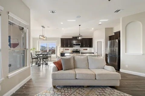 a living room with furniture and kitchen view