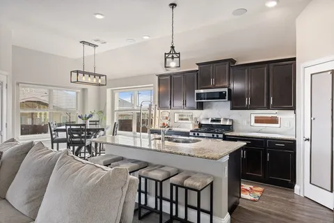 a kitchen with granite countertop a center island and appliances