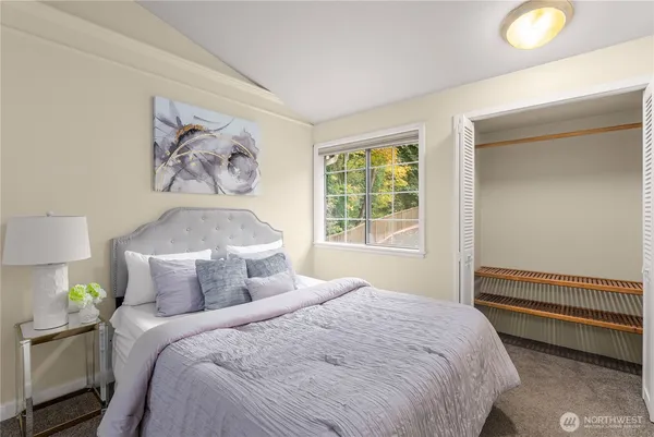 a bedroom with a bed and a painting on the wall