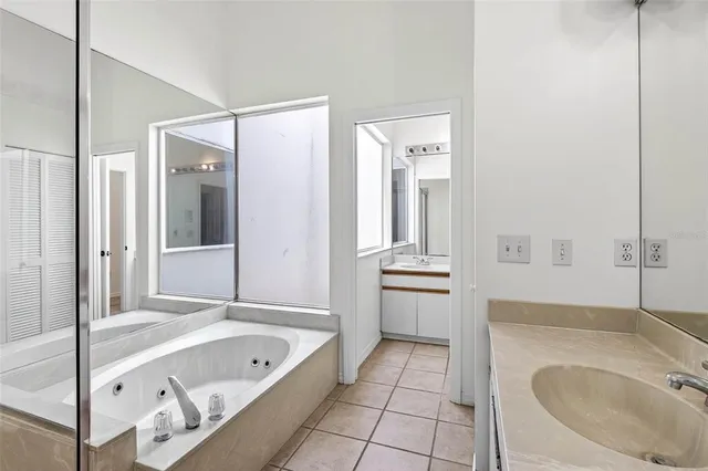 a bathroom with a tub sink and mirror