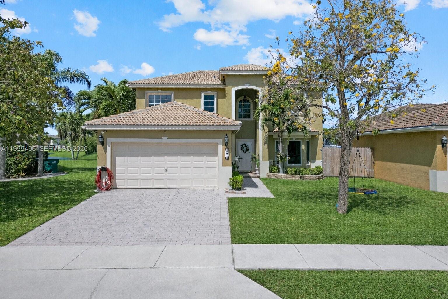 a front view of a house with a yard and garage