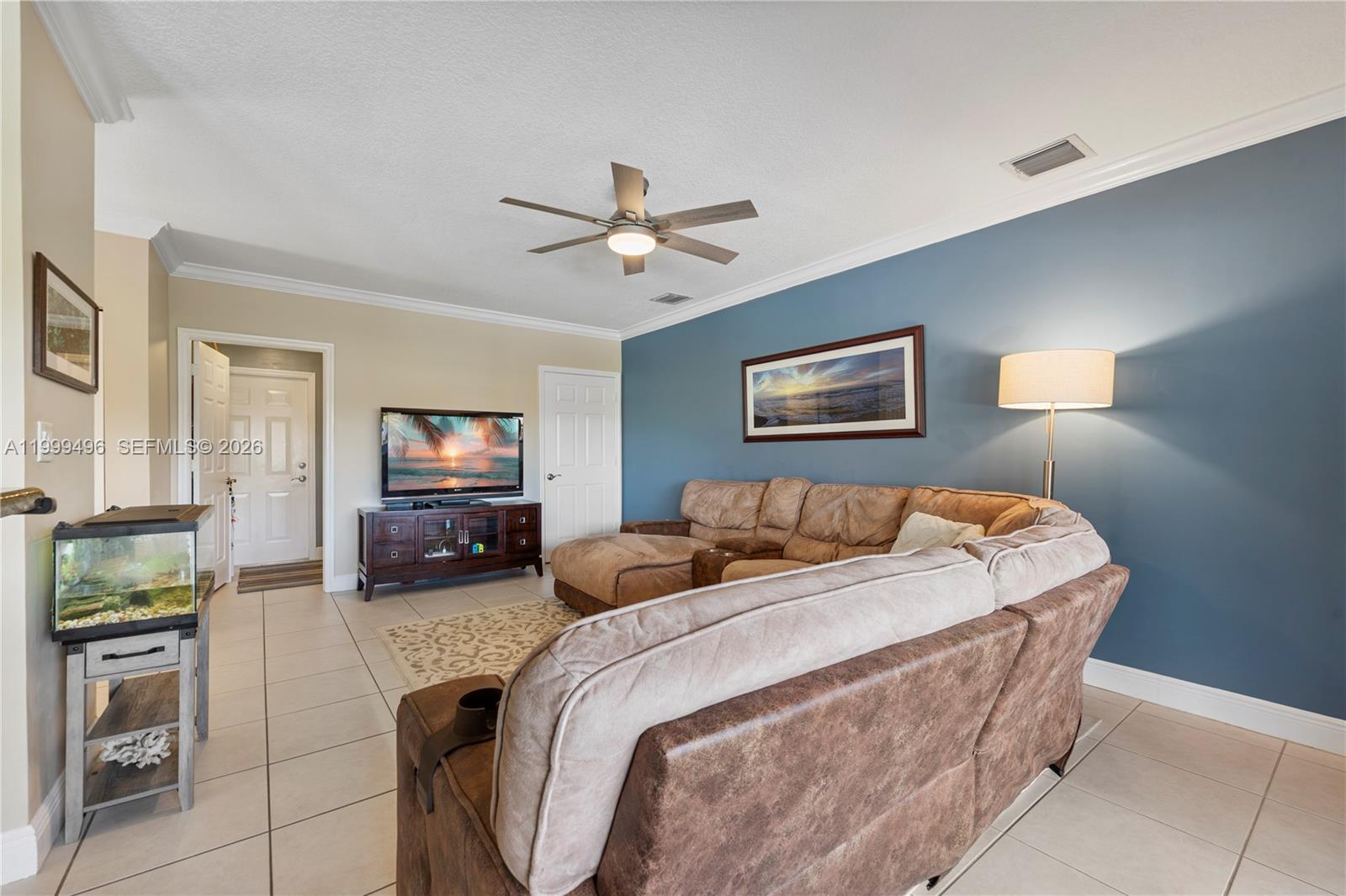 20918 Southwest 89th Path Cutler Bay, FL 33189 - Photo 17 of 47 a bedroom with a bed a couch and a flat tv screen on a dresser