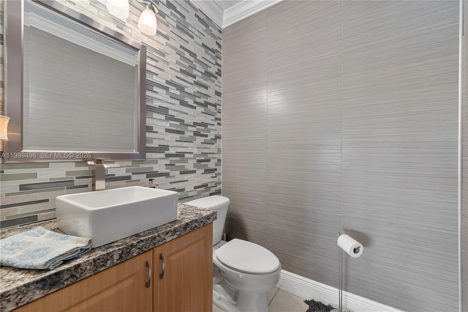 20918 Southwest 89th Path Cutler Bay, FL 33189 - Photo 20 of 47 a bathroom with a granite countertop toilet a sink and mirror