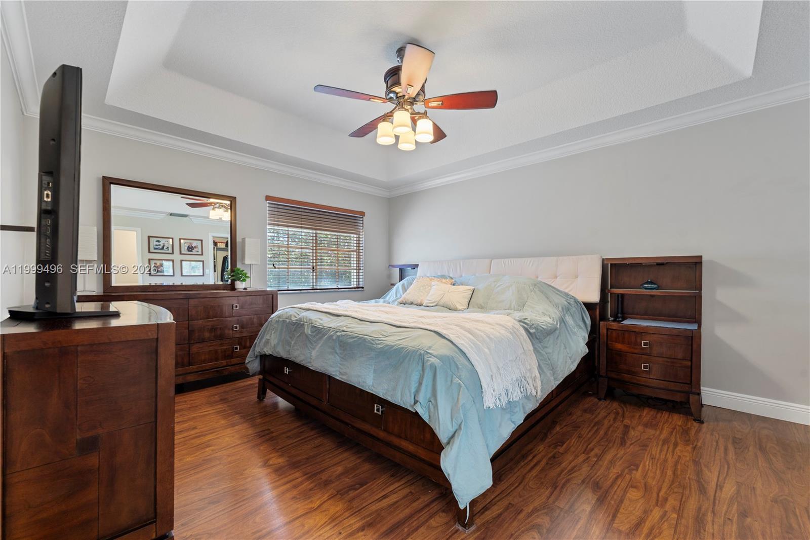 20918 Southwest 89th Path Cutler Bay, FL 33189 - Photo 22 of 47 a bedroom with a bed and a dresser with wooden floor