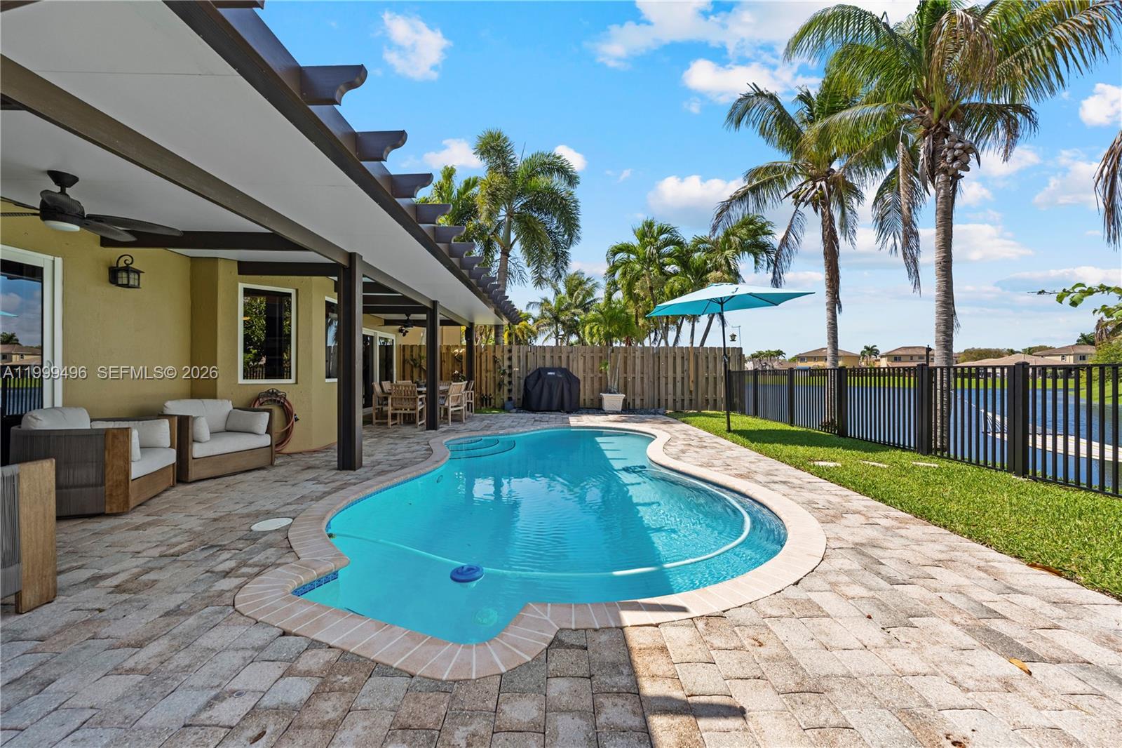 20918 Southwest 89th Path Cutler Bay, FL 33189 - Photo 35 of 47 a view of a swimming pool with a lounge chair and palm trees