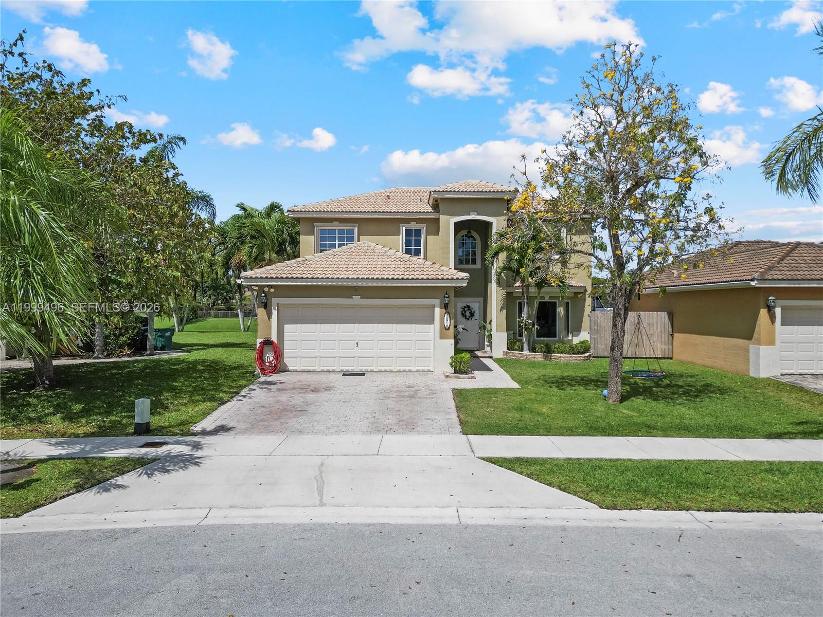 20918 Southwest 89th Path Cutler Bay, FL 33189 - Photo 46 of 47 a front view of a house with a yard and garage