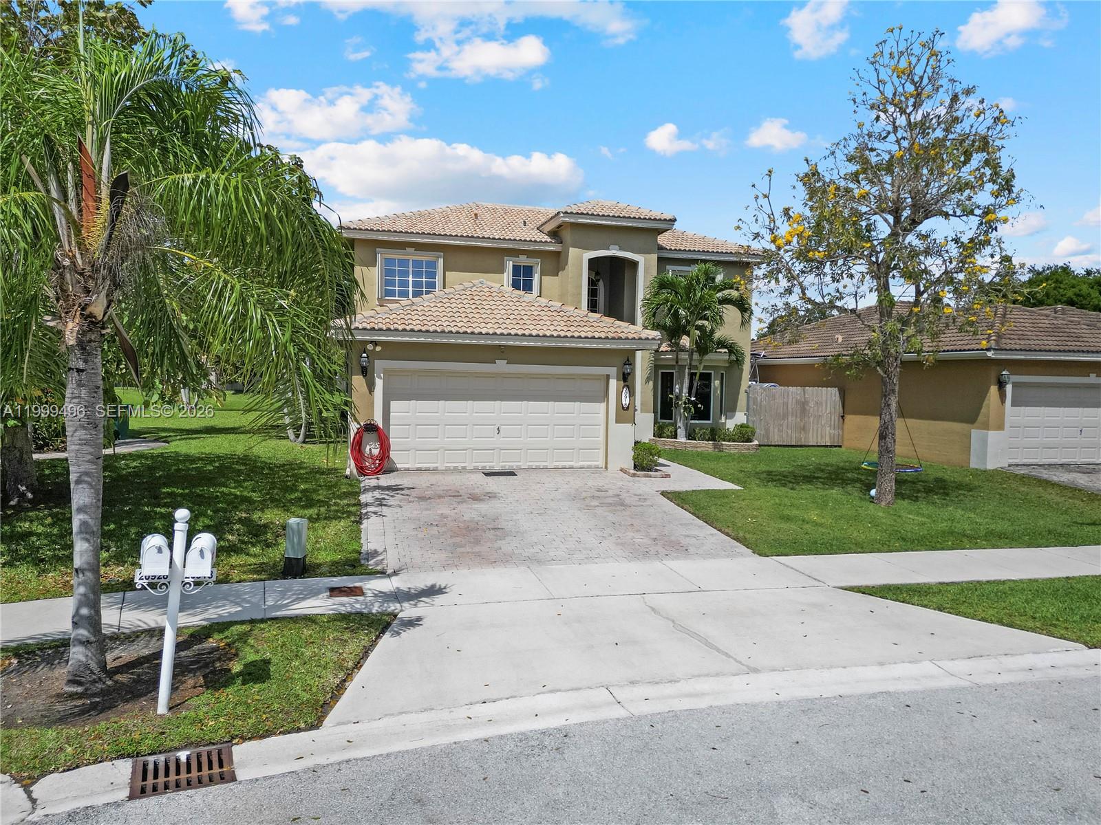 20918 Southwest 89th Path Cutler Bay, FL 33189 - Photo 47 of 47 a front view of a house with a yard and a garage