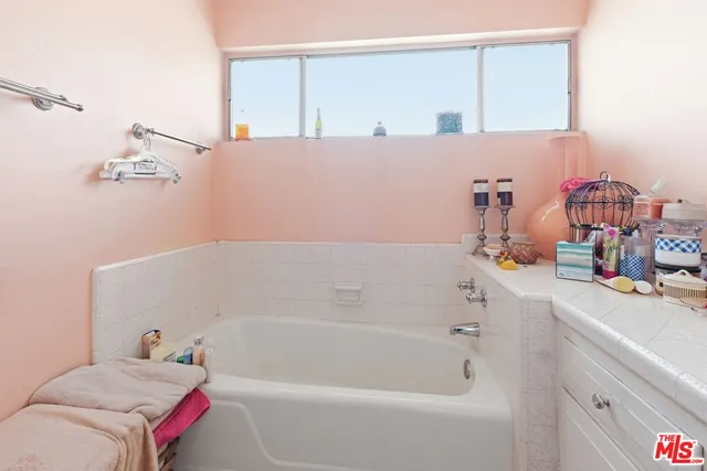a bathroom with a bathtub sink and mirror