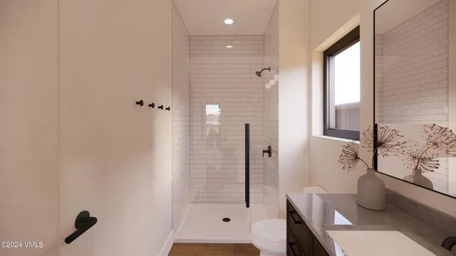 a bathroom with a granite countertop sink a toilet and shower
