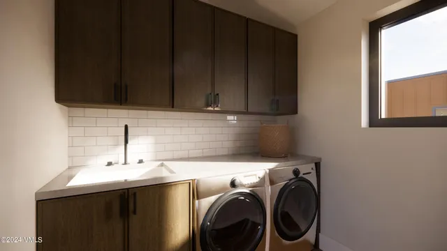 a utility room with sink dryer and washer