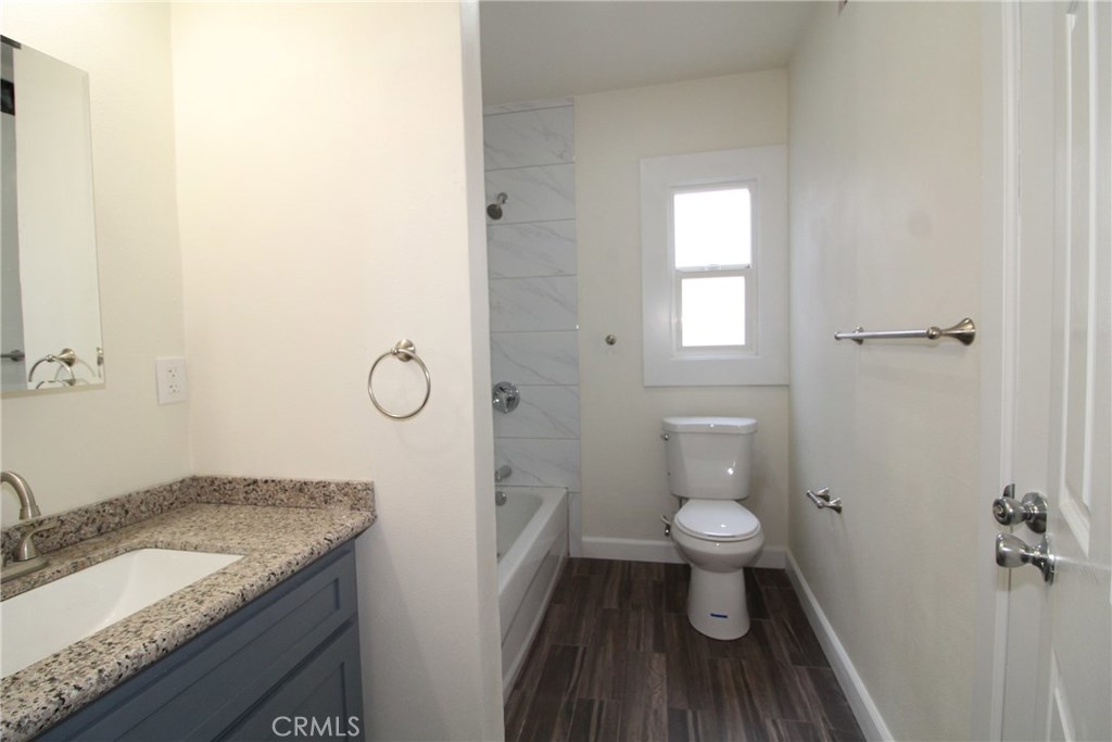 7024 Middleton Street, Unit B Huntington Park, CA 90255 - Photo 8 of 8 a bathroom with a granite countertop toilet and a sink
