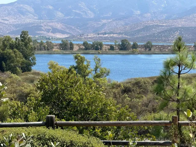 an aerial view of a residential houses with outdoor space and lake view