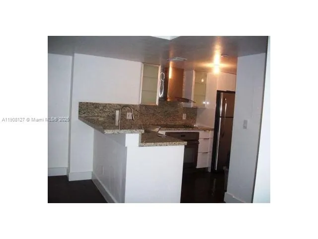 a kitchen with a sink and refrigerator