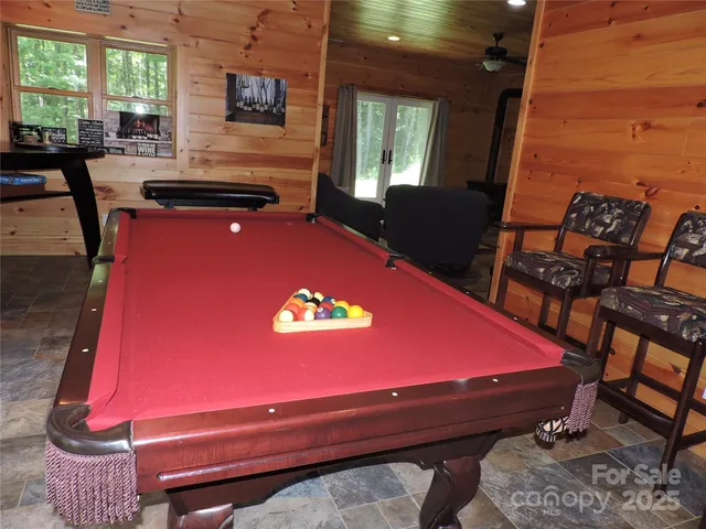 a room with pool table and windows