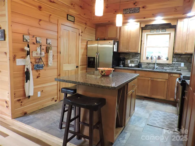a kitchen with stainless steel appliances granite countertop table chairs sink and cabinets