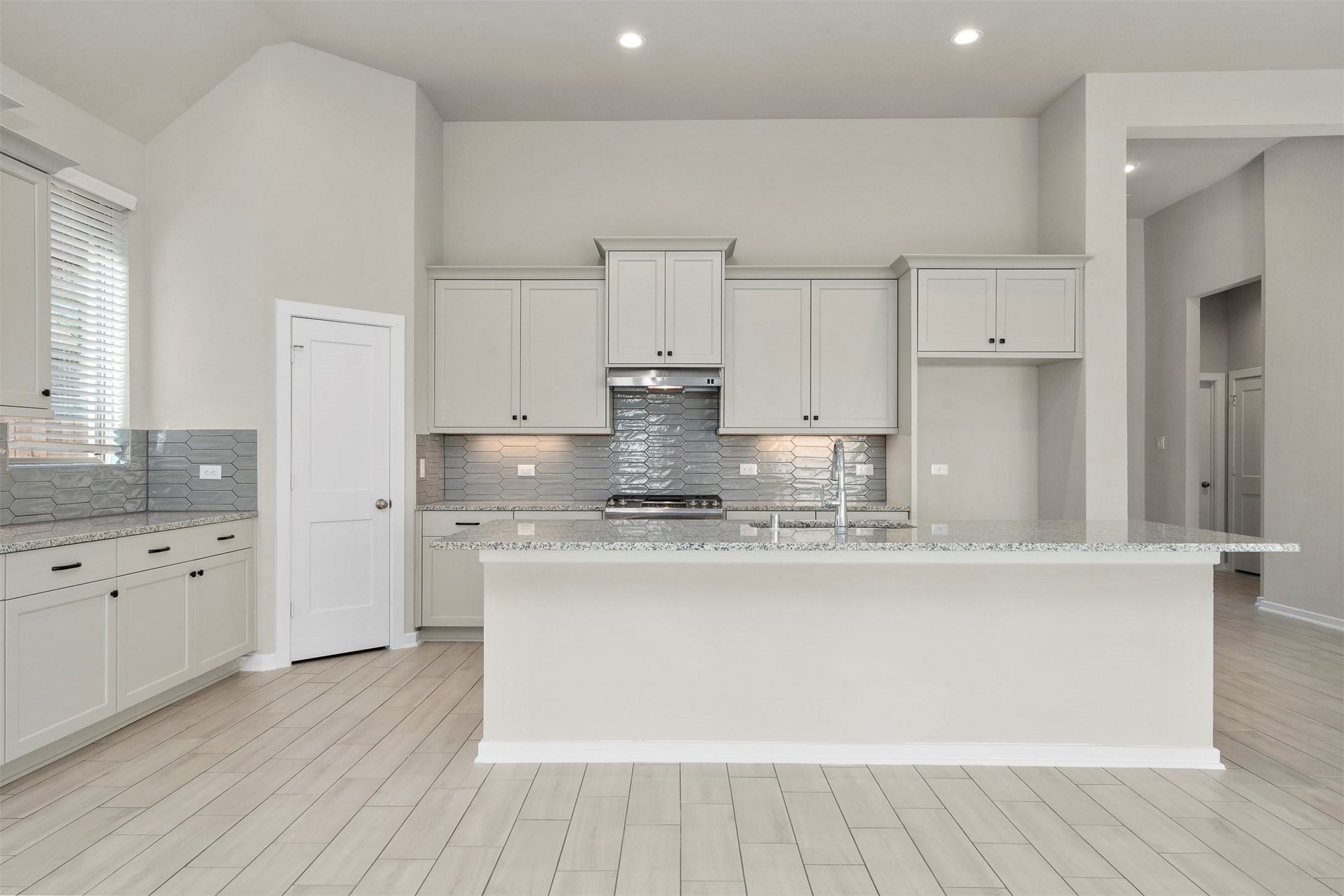107 Yellow Perch Way Conroe, TX 77318 - Photo 8 of 36 a large kitchen with granite countertop a white stove top oven and white cabinets