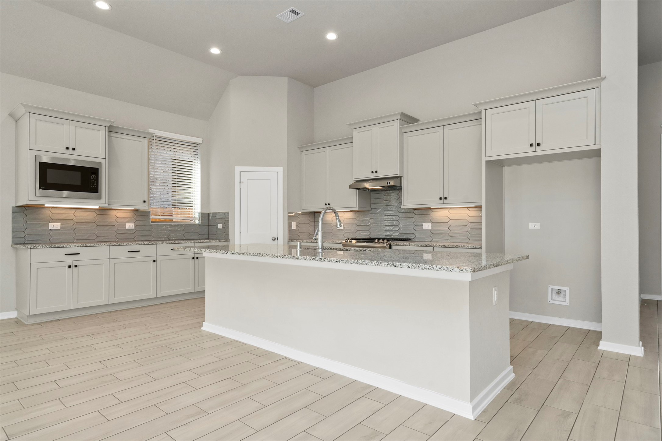 107 Yellow Perch Way Conroe, TX 77318 - Photo 10 of 36 a large kitchen with granite countertop a sink a stove a refrigerator and white cabinets