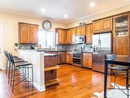 16308 Lake Loop Austin, TX 78734 - Photo 7 of 11 a kitchen with stainless steel appliances granite countertop wooden cabinets a stove a sink a dining table and chairs