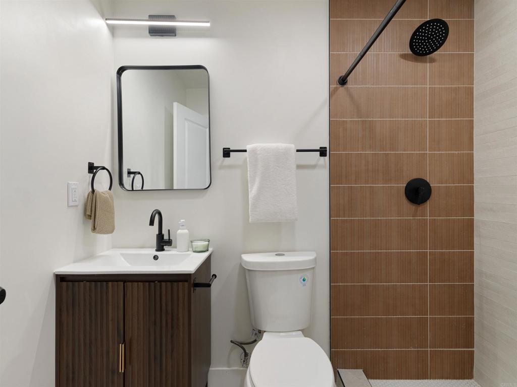 1482 Avocado Road Oceanside, CA 92054 - Photo 12 of 35 a bathroom with a sink a toilet a mirror and shower