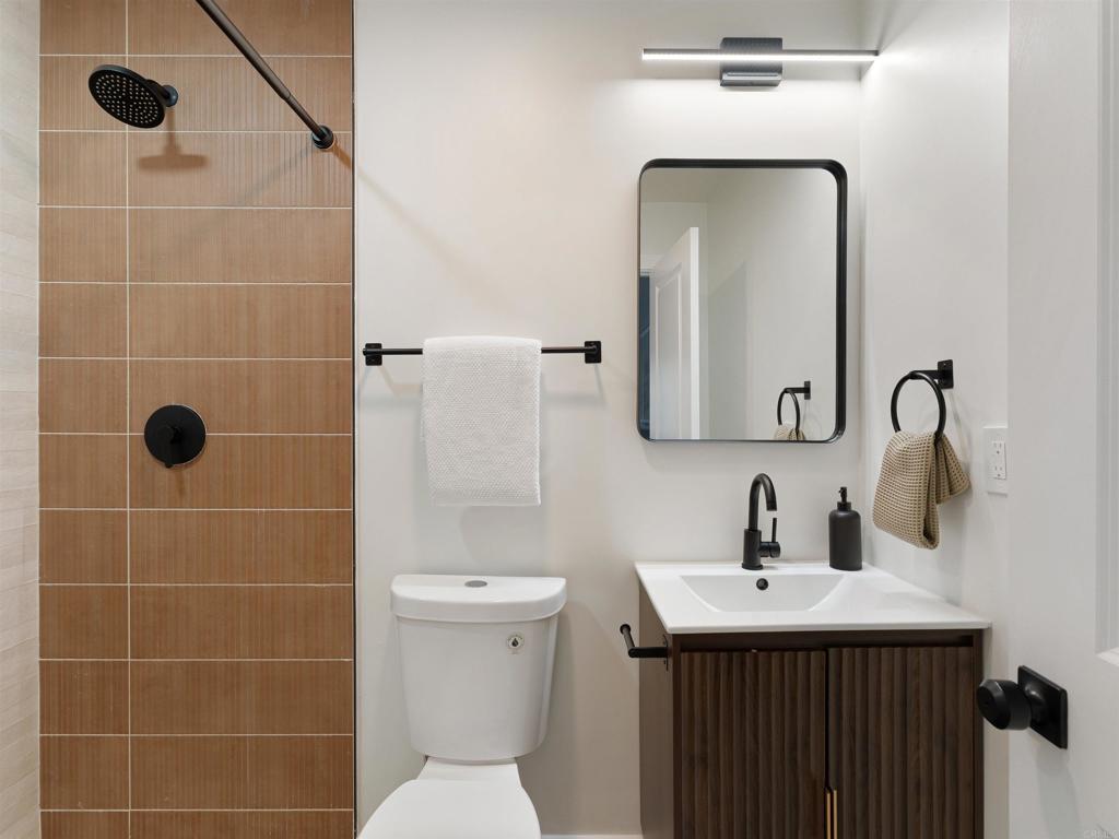 1482 Avocado Road Oceanside, CA 92054 - Photo 30 of 35 a bathroom with a toilet sink shower and mirror