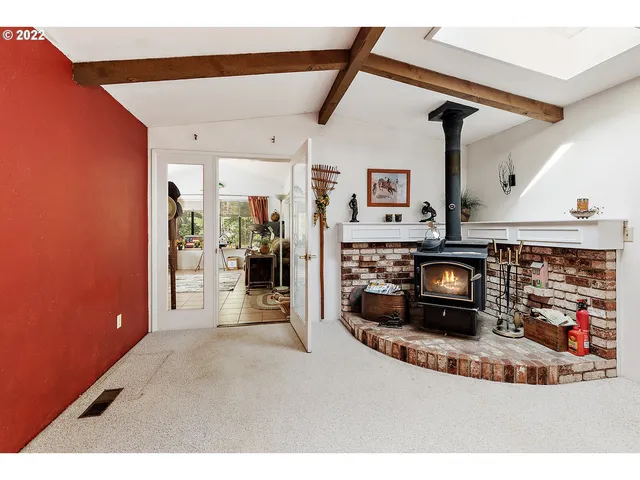 a view of a livingroom with wooden floor and a fireplace