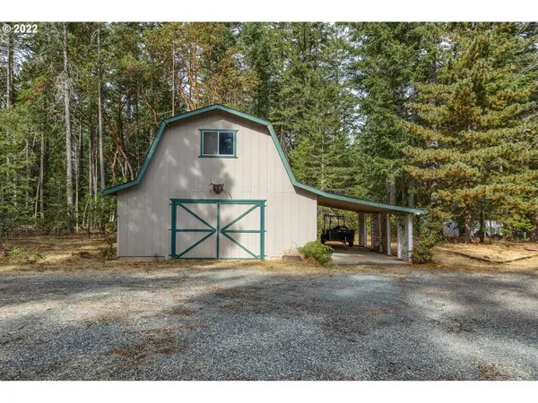a backyard of a house with wooden fence and large trees