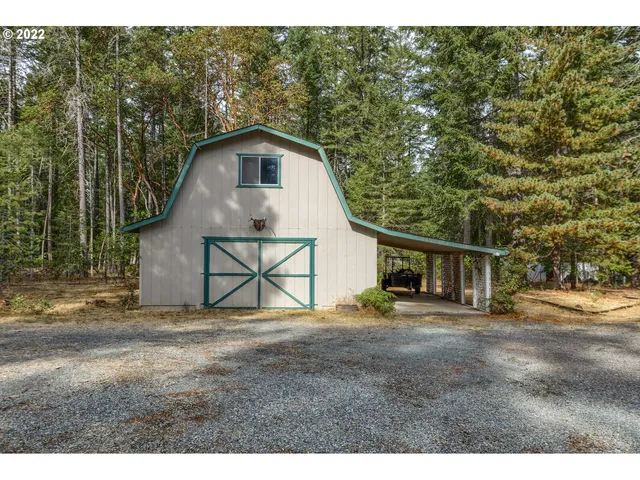 a backyard of a house with wooden fence and large trees