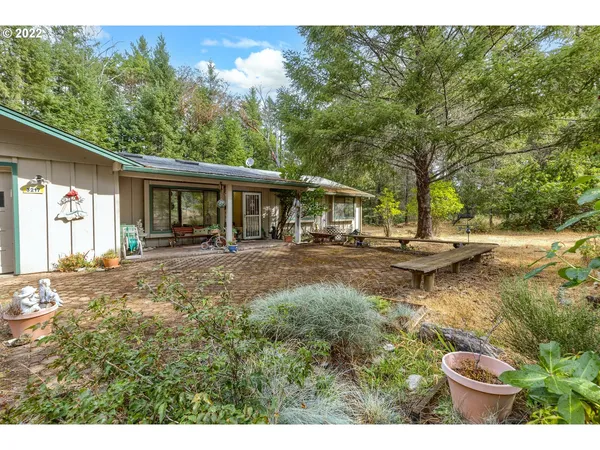 a view of a house with backyard and sitting area