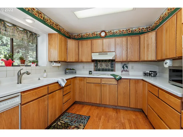 a kitchen with stainless steel appliances granite countertop a sink a stove cabinets and a kitchen island
