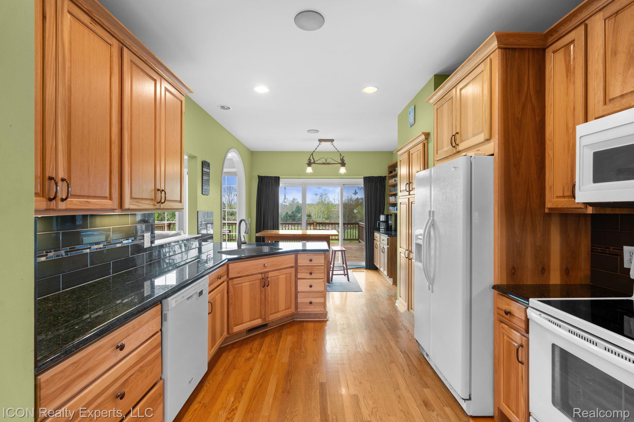 5128 Baldwin Road Metamora, MI 48455 - Photo 26 of 68 Kitchen with a peninsula, white appliances, tasteful backsplash, light wood-type flooring, and wood finish cabinetry