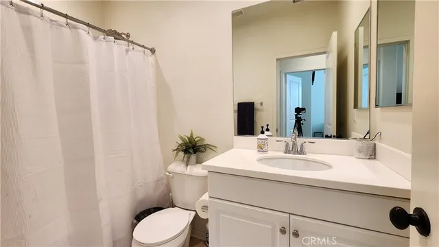 a bathroom with a sink vanity mirror and toilet