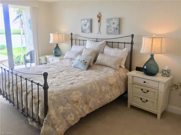 a bedroom with a bed a dresser and next to a window